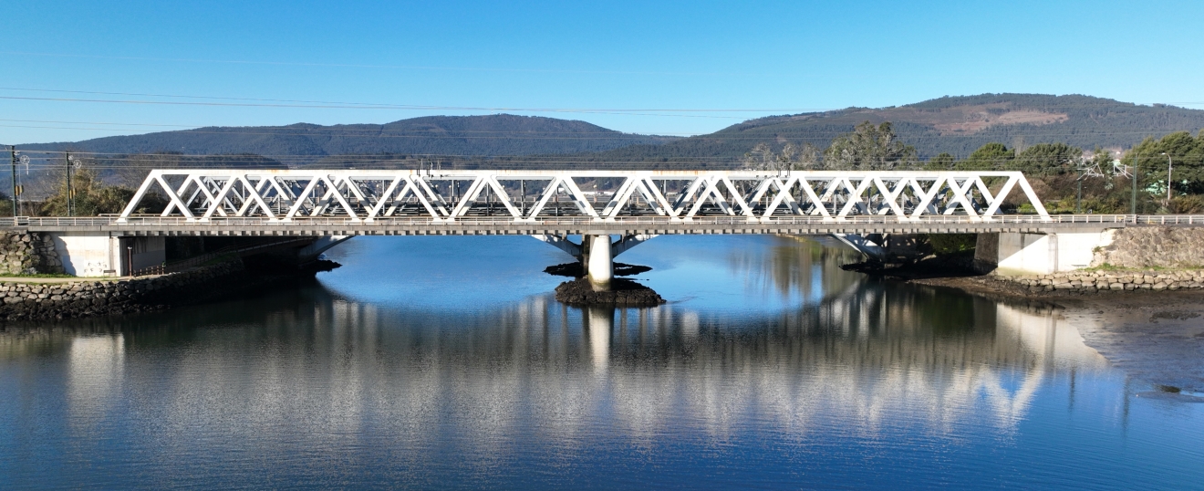 Puente de celosía blanco reflejado en la ría. Fotografía aérea con dron de VISUAIR