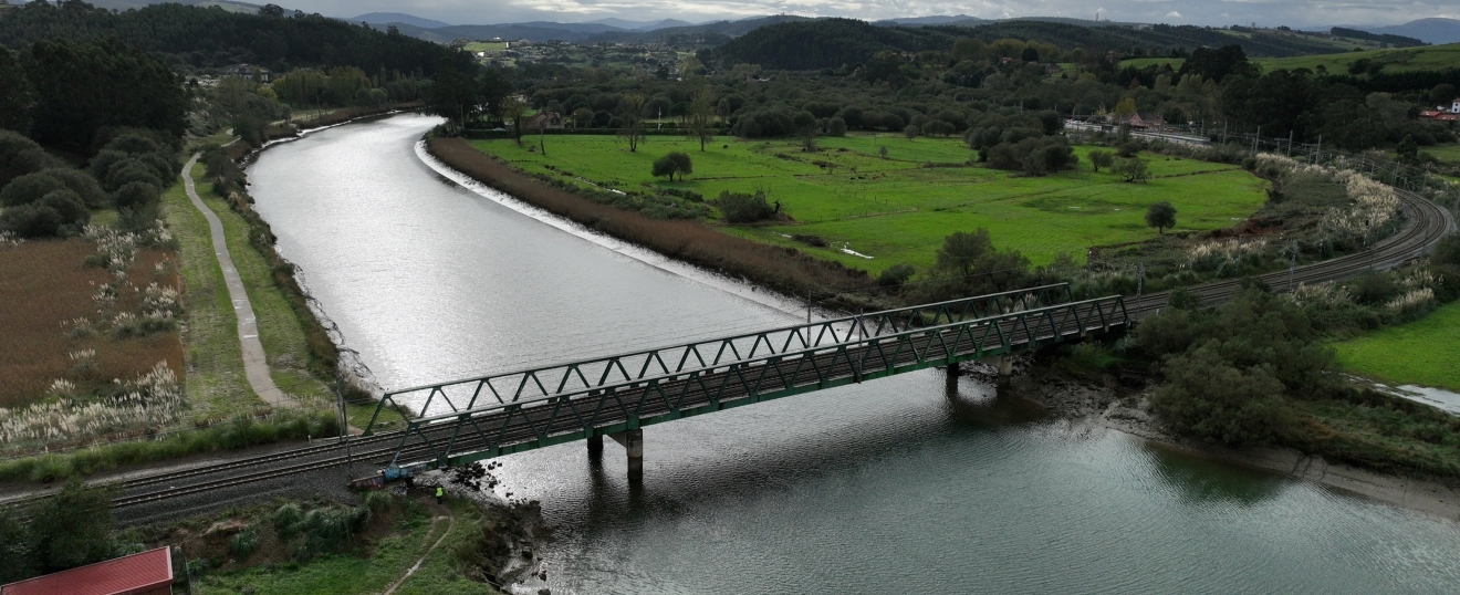 Puente de celosía sobre la ría entre prados de Cantabria. Fotografía aérea con dron de VISUAIR